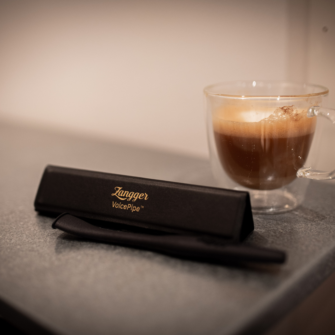 Zangger VoicePipe in its case on a kitchen counter beside a cup of coffee, ready for a morning warm-up