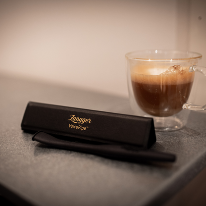 Zangger VoicePipe in its case on a kitchen counter beside a cup of coffee, ready for a morning warm-up