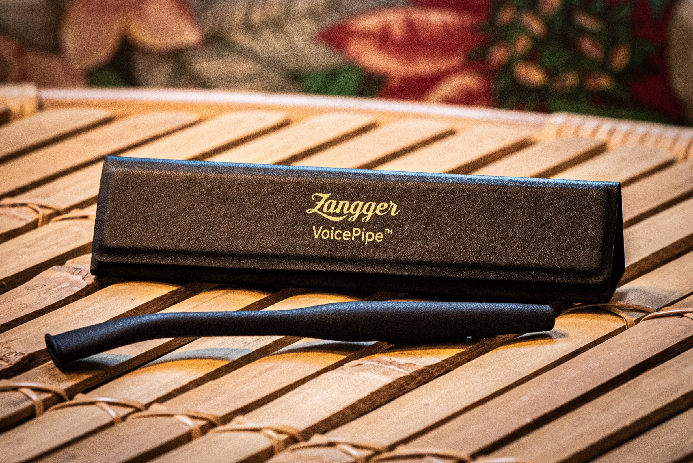 The Zangger VoicePipe and its gold-stamped case resting on a bamboo table