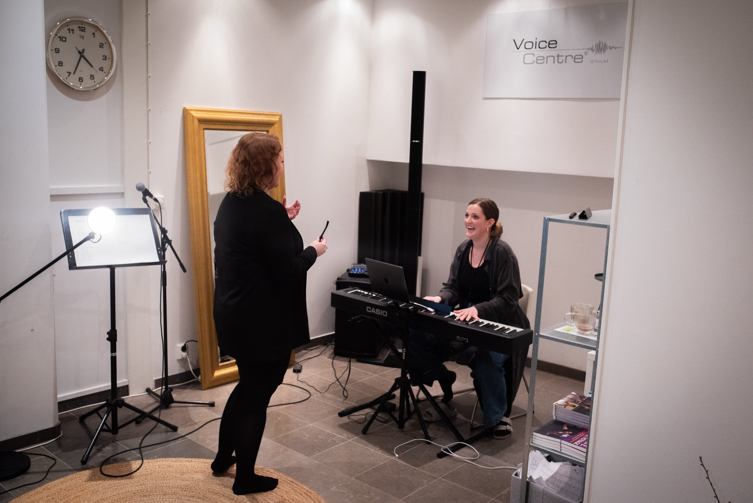 A singing lesson at Voice Centre Stockholm, the student holding a Zangger VoicePipe while the coach plays piano